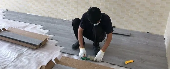 SPC rigid core vinyl flooring installation process showing click lock plank engagement at 15℃angle with expansion spacers along wall and properly prepared flat subfloor SPC rigid core vinyl flooring installation process showing click lock plank engagement at 15℃angle with expansion spacers along wall and properly prepared flat subfloor