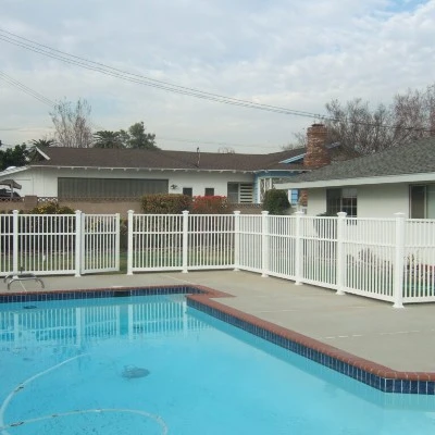 White vinyl pool fence panel with square pickets and straight top rail installed as a code compliant barrier around a residential pool area White vinyl pool fence panel with square pickets and straight top rail installed as a code compliant barrier around a residential pool area
